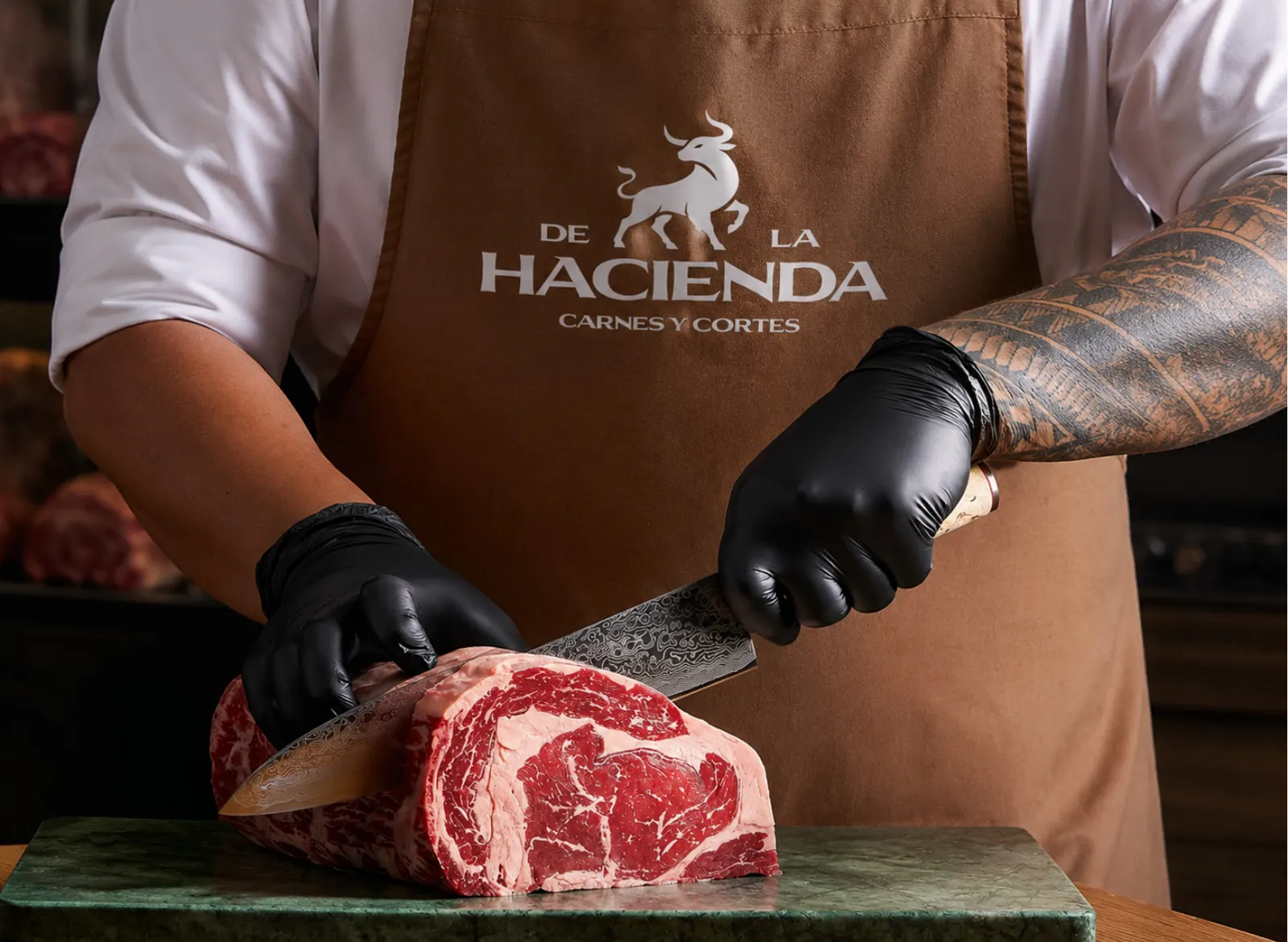 Carnicero de De La Hacienda cortando una pieza de res